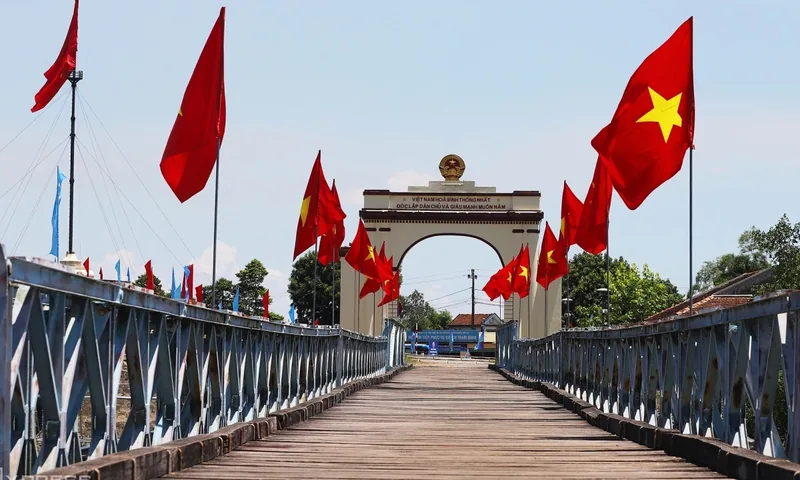 Cờ đỏ Việt Nam tung bay dọc cầu Hiền Lương dẫn đến cổng chào ở tỉnh Quảng Trị.