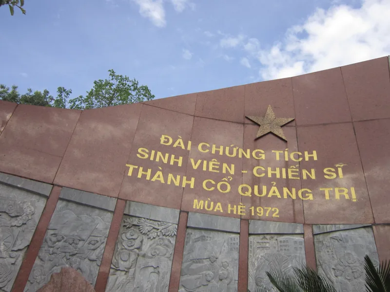 Bức tường tưởng niệm cong với sao vàng và chữ khắc tưởng nhớ sinh viên chiến sĩ Thành cổ Quảng Trị, mùa hè 1972.