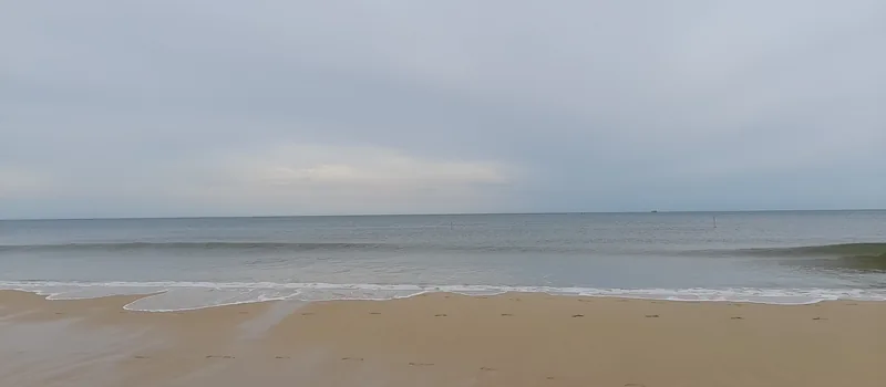 Những con sóng nhẹ vỗ vào bãi cát yên tĩnh dưới bầu trời nhiều mây tại biển Cửa Việt.
