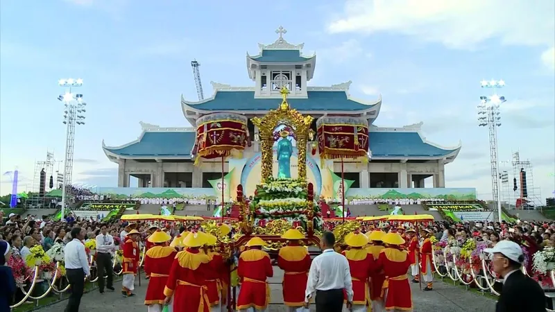 Đông đảo người dân tham dự lễ rước tượng với đoàn khiêng mặc trang phục truyền thống trước công trình mái ngói ở Quảng Trị.